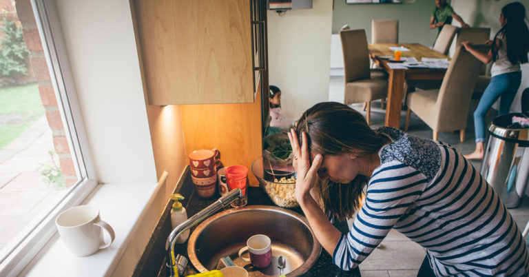 a woman holding her head standing over a sink - Anxiety and Blood Sugar Cover