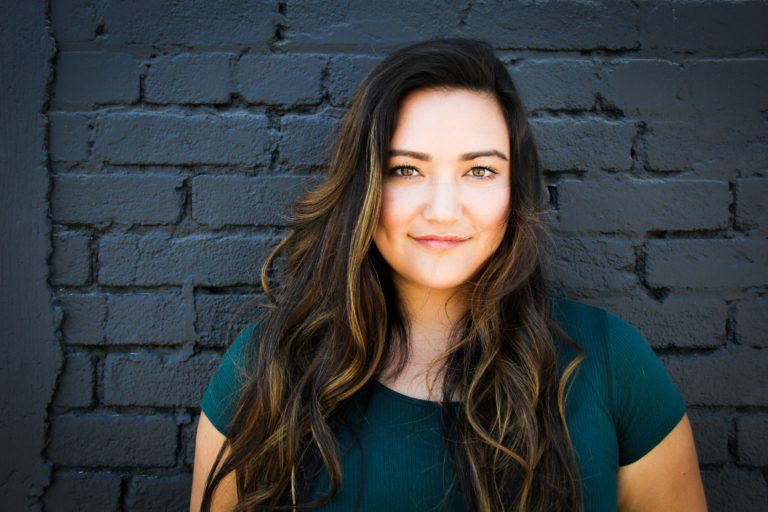 Woman standing in front of a black brick wall