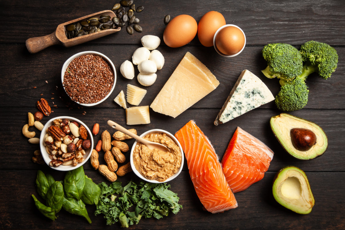 black table with eggs, meats, cheeses and vegetables on it.