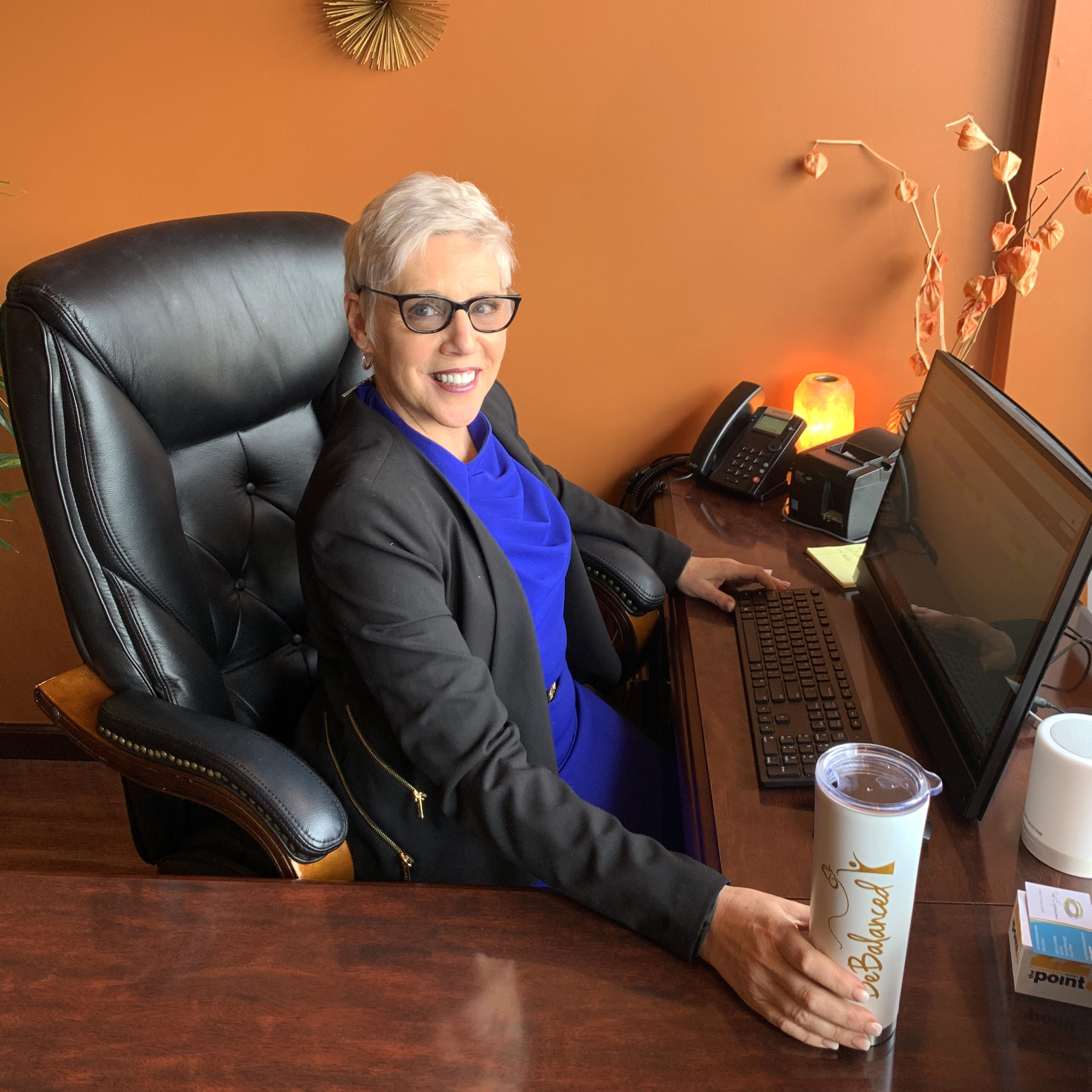 Gold-Blobs BeBalanced weight loss consultant sits behind computer