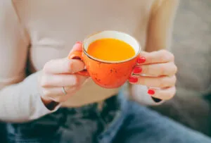 woman holding a cup of green tea