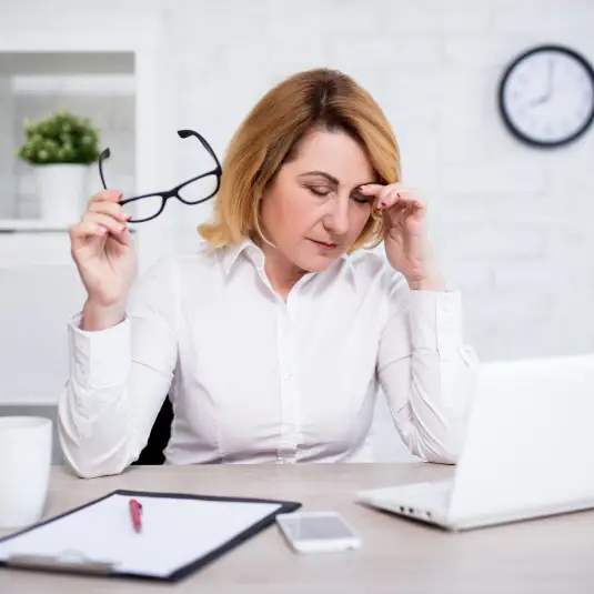 low-energy Middle aged woman struggling to concentrate at desk